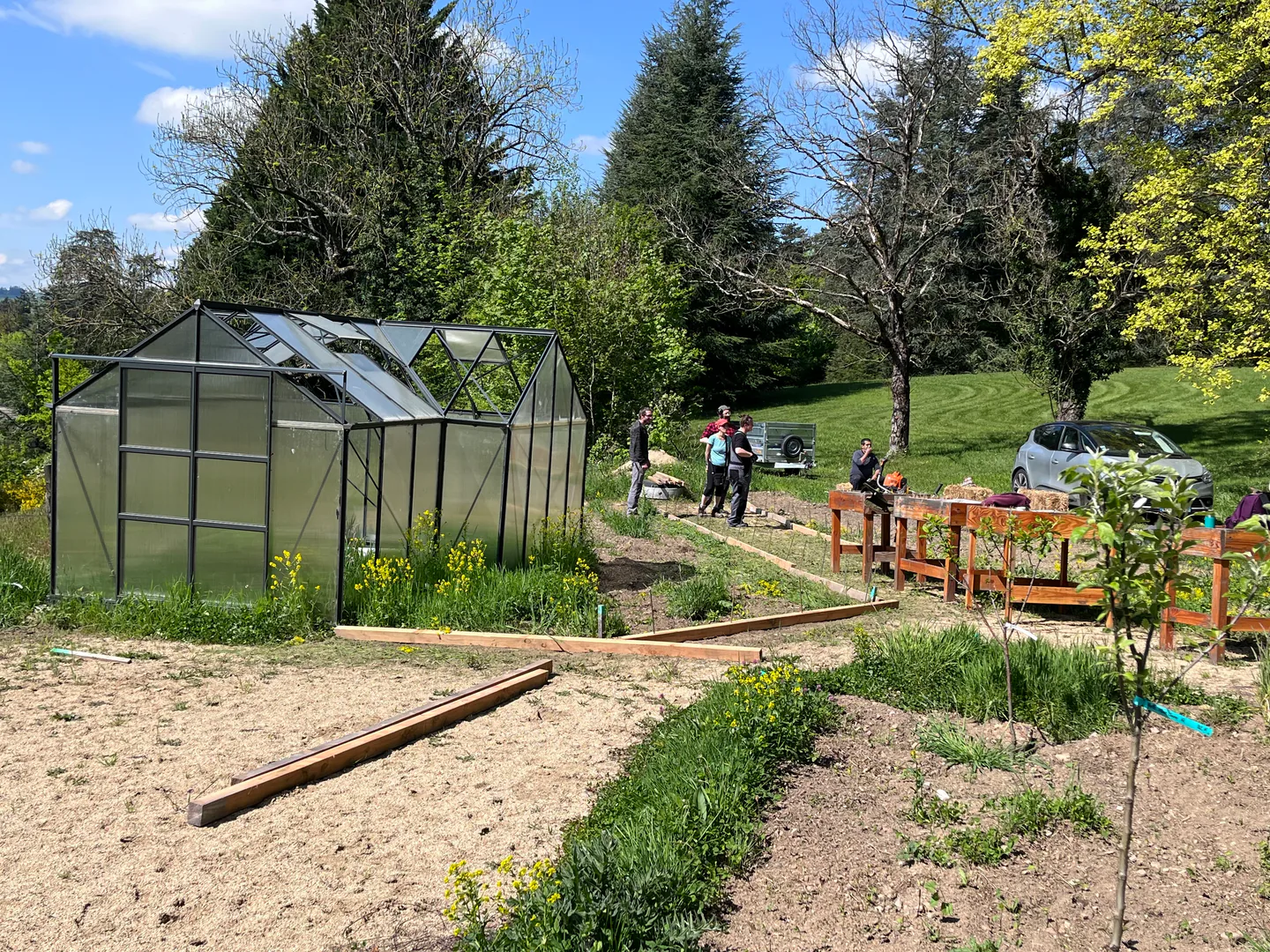 Jardin de santé aménagé avec serre, allées et tables de culture