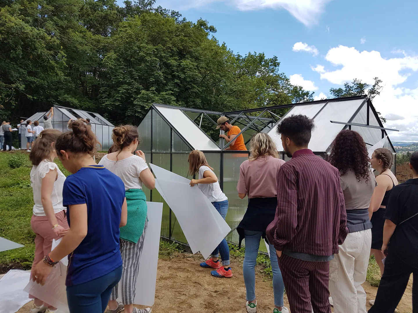 Participants à un atelier collectif autour d’une serre de jardin